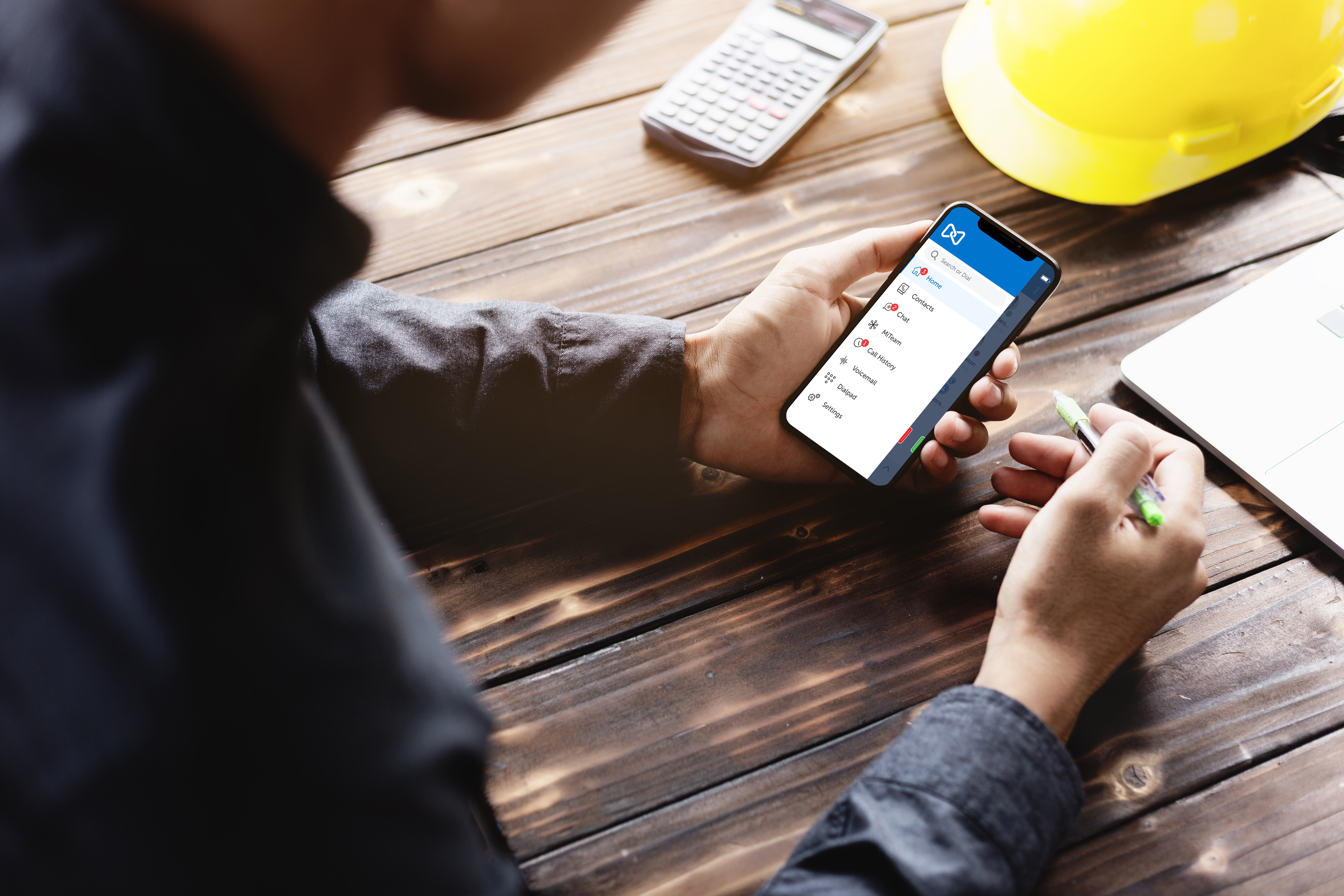 construction worker using mitel app on his phone at a jobsite